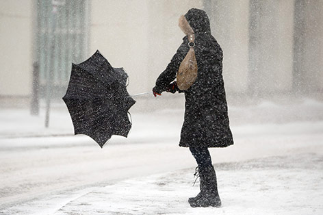 © APA/Georg Hochmuth Frau mit Schirm im Schnee