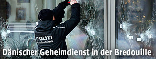 Polizist bei untersucht die Einschusslöcher am Tatort
