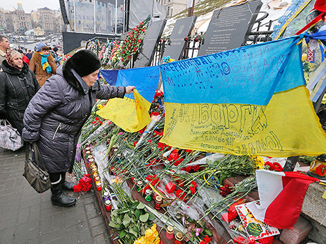 © APA/EPA/Sergey Dolzhenko Trauernde Frau vor Blumen auf dem Maidan