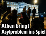 Fl&uuml;chtlinge sitzen vor griechischem Parlament