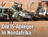 Algerischer Soldat vor zerst&ouml;rten Fahrzeugen