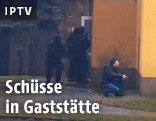 Polizist mit gezogener Waffe und Spezialeinheit