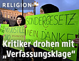 Menschen demonstrieren gegen das Islamgesetz