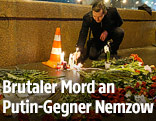 Ein Mann legt Blumen an die Stelle des Tatorts