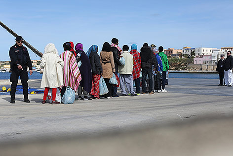 © Reuters/Alessandro Bianchi Flüchtlinge im Hafen von Lampedusa erhalten Anweisungen von Beamten