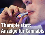 Ein junger Mann macht einen Zug von einem Joint