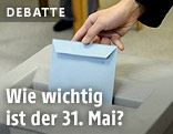 Eine Frau wirft ihren Stimmzettel in die Wahlurne