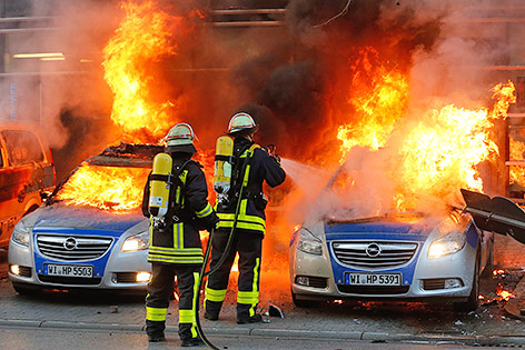 © APA/AP/Michael Probst Feuerwehrmänner löschen brennende Autos