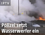 Wasserwerfer und brennendes Auto