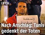 Ein Mann h&auml;lt einen Zettel und eine Kerze