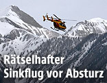 Ein Hubschrauber vor schneebedeckten Bergen