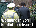Polizist und Ermittler am Hauseingang des Kopiloten