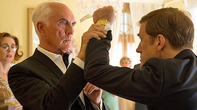 © Studiocanal Christoph Waltz attackiert in einer Szene des Films "Big Eyes" Terence Stamp mit einer Gabel