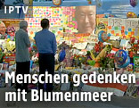 Menschen gedenken Lee vor einem Blumenmeer