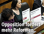 Grüne Nationalratsabgeordnete halten ein Schilder in der Hand