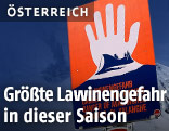 Ein Lawinenwarnschild mit der Aufschrift "Lawinengefahr"