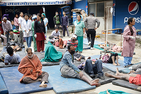 © APA/EPA/Narendra Shrestha Verletzte Menschen werden auf der Straße medizinisch versorgt