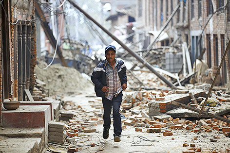 © Reuters/Navesh Chitrakar Mann rennt während eines Nachbebens durch die zerstörten Straßen von Bhaktapur