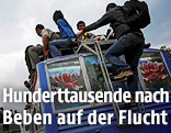 Menschen klettern auf Fahrzeuge um die nepalesische Hauptstadt Kathmandu nach dem Erdbeben zu verlassen