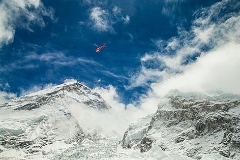 © AP/Courtesy of 6summitschallenge.com/Elia Saikaly Ein Hubschrauber fliegt beiM Mount Everst