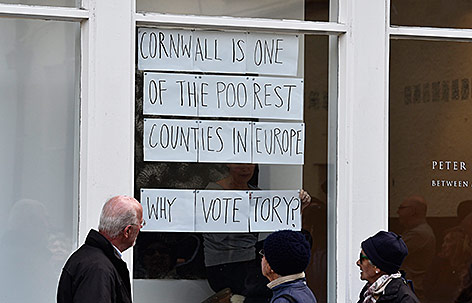 © Reuters/Toby Melville Menschen in Cornwall sthehen vor einer Wahlwerbung