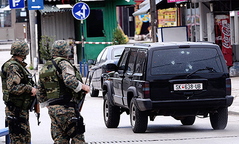 © APA/AP/Radovan Vujovic Polizisten stehen vor einem Auto mit Einschusslöchern