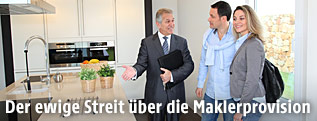 Ein Makler führt ein Paar durch eine Wohnung