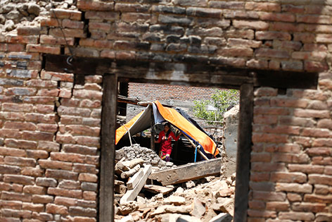 Menschen zelten in zerstörtem Haus in Nepal