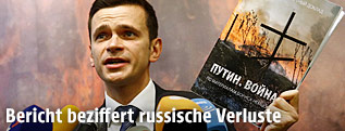 Russischer Oppositioneller hält den Nemzow-Bericht in der Hand
