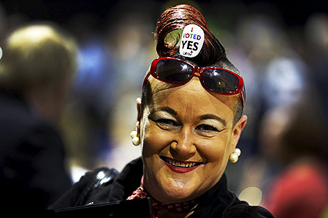 Eine Frau hat im Kopfhaar einen Sticker mit der Aufschrift "I voted Yes"