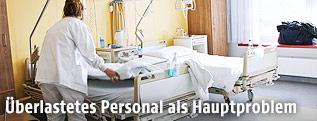 Spitalspersonal schiebt ein Krankenbett