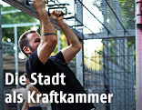 Sportler zieht sich an Eisenstange hoch