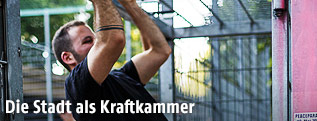 Sportler zieht sich an Eisenstange hoch