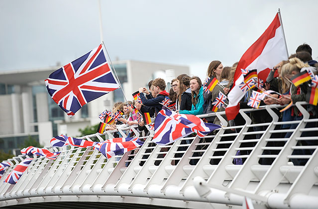 © Reuters/Stefanie Loos Schaulustige mit Flaggen und Fahnen auf einer Brücke