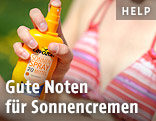 Frau besprüht sich mit Sonnencreme