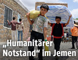 Syrische Kinder tragen Hilfsgüter
