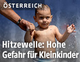 Ein Kleinkind vor Wasserfontänen