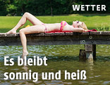 Frau liegt auf einem Badesteg