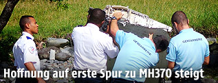 Polizisten begutachten das Wrackteil
