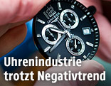 Mitarbeiter zeigt eine Uhr