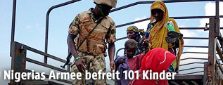 Nigerianischer Soldat mit befreiten Geiseln