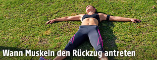 Sportlerin liegt im Gras