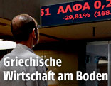 Mitarbeiter der griechischen Börse vor einem Display mit Kursveränderungen