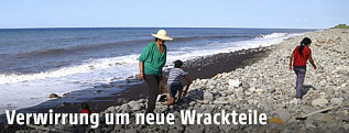 Drei Personen suchen einen Strand auf La Reunion ab
