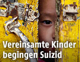 Kind schaut durch Türspalt