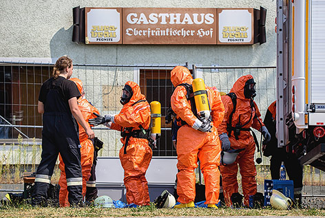 © APA/EPA/Nicolas Armer Einsatzkräfte in Spezialanzügen