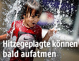 Bub läuft durch einen Springbrunnen
