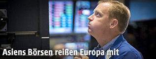 Mann begutachtet Kurse an der Börse