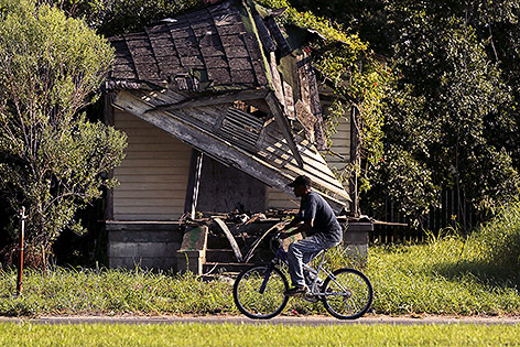 © Reuters/Jonathan Bachman Mann radelt bei einem zerstörten Haus in New Orleans vorbei