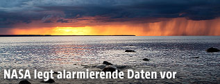 Sonnenuntergang am Meer mit einer Regenwolke